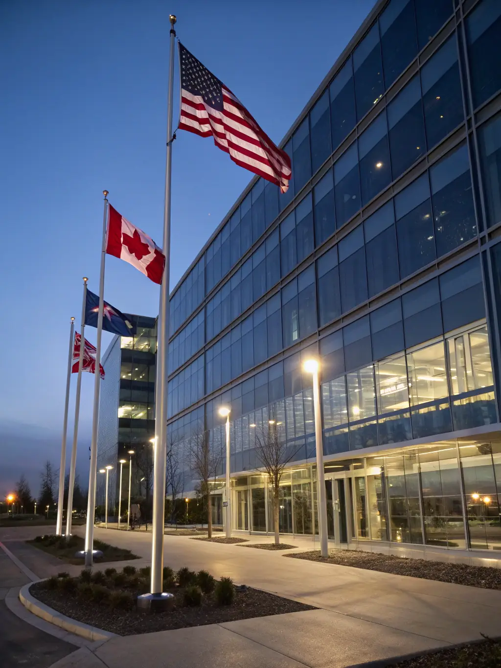 A photograph of the Canadian flag waving in front of modern office buildings, symbolizing the opportunities and requirements for immigration to Canada through Global Travel Matrix.